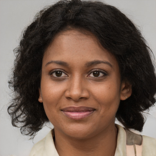 Joyful black young-adult female with medium  brown hair and brown eyes