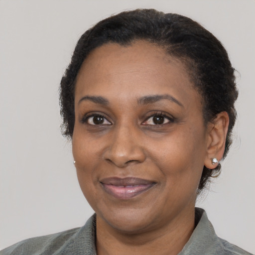 Joyful black adult female with short  black hair and brown eyes