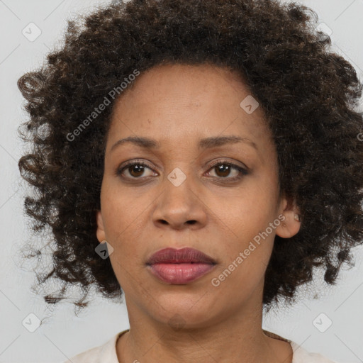 Joyful black adult female with medium  brown hair and brown eyes