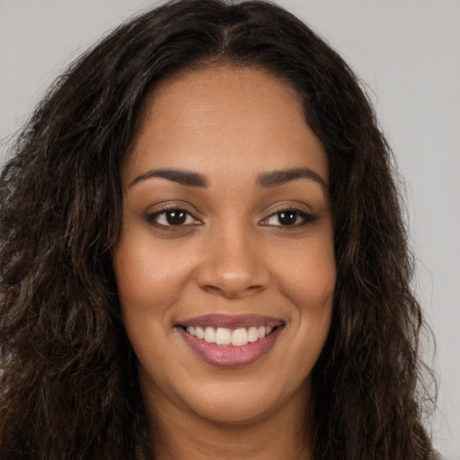 Joyful latino young-adult female with long  brown hair and brown eyes