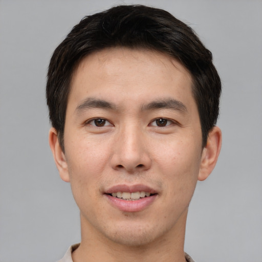 Joyful asian young-adult male with short  brown hair and brown eyes
