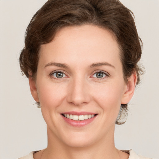 Joyful white young-adult female with medium  brown hair and green eyes