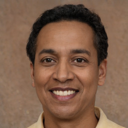 Joyful latino adult male with short  black hair and brown eyes