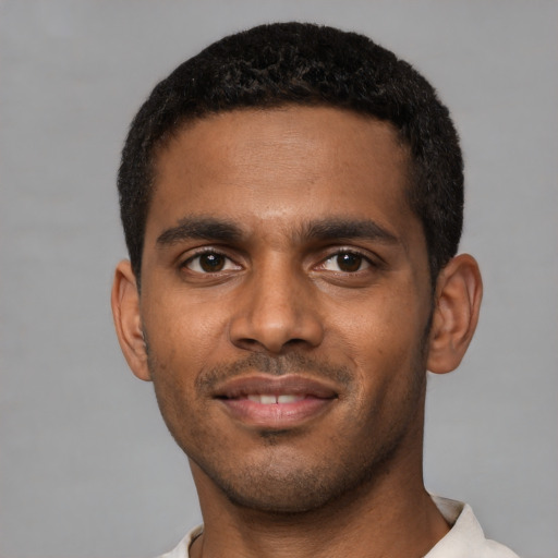 Joyful black young-adult male with short  black hair and brown eyes