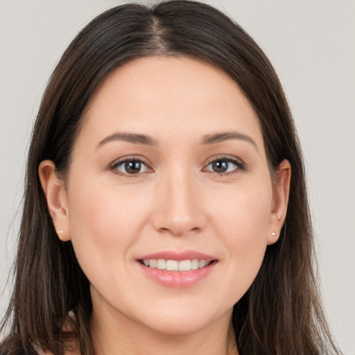 Joyful white young-adult female with long  brown hair and brown eyes