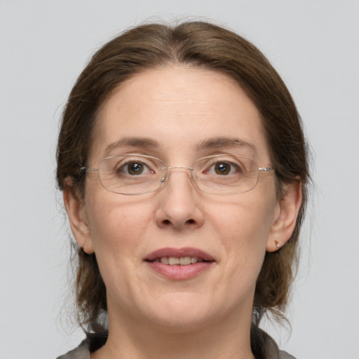 Joyful white adult female with medium  brown hair and grey eyes