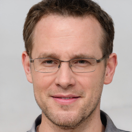 Joyful white adult male with short  brown hair and grey eyes