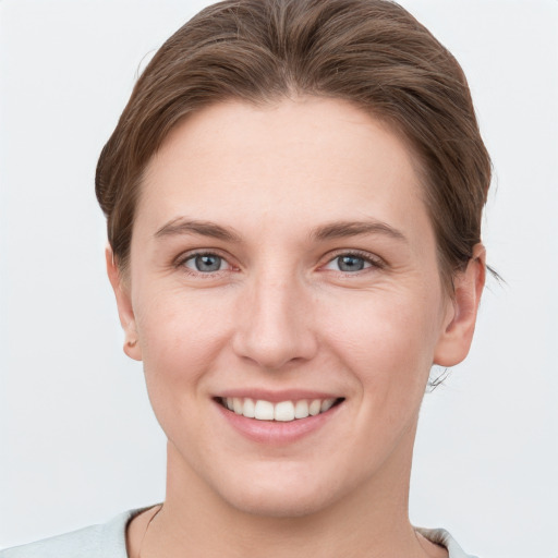 Joyful white young-adult female with short  brown hair and grey eyes