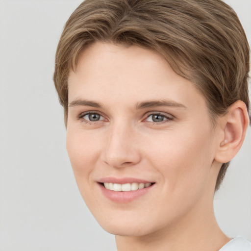 Joyful white young-adult female with short  brown hair and grey eyes