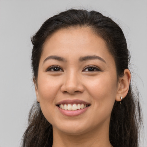 Joyful latino young-adult female with long  brown hair and brown eyes