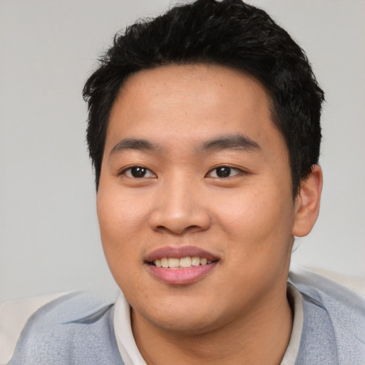 Joyful asian young-adult male with short  black hair and brown eyes