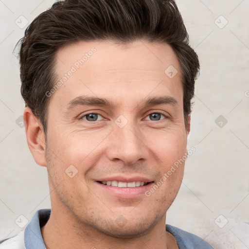 Joyful white young-adult male with short  brown hair and grey eyes