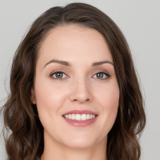 Joyful white young-adult female with long  brown hair and green eyes