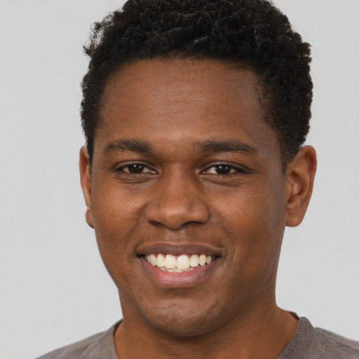 Joyful black young-adult male with short  brown hair and brown eyes