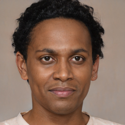 Joyful black adult male with short  black hair and brown eyes