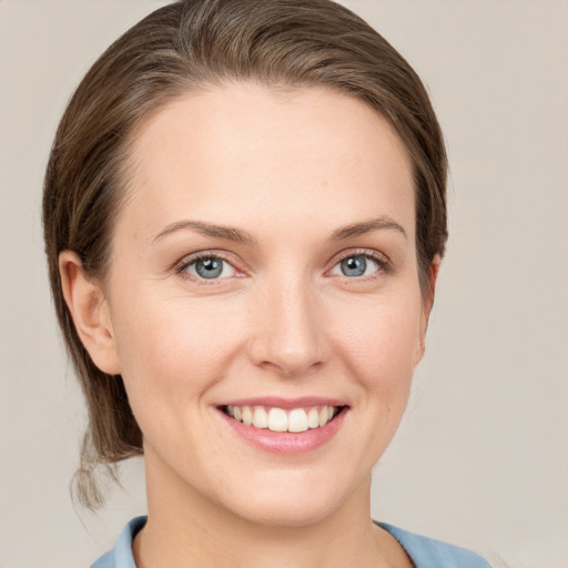 Joyful white young-adult female with medium  brown hair and grey eyes