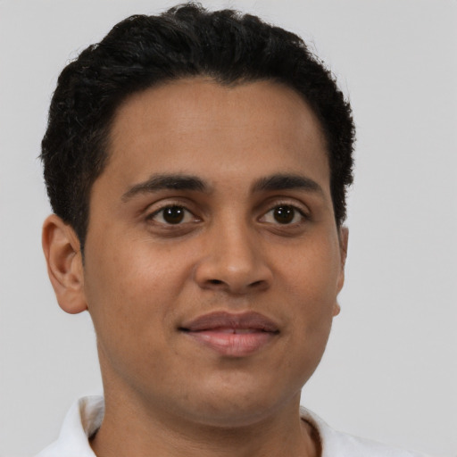 Joyful latino young-adult male with short  brown hair and brown eyes