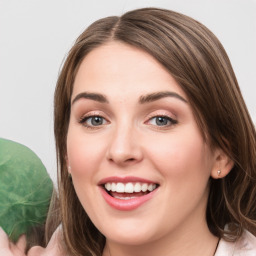 Joyful white young-adult female with medium  brown hair and green eyes