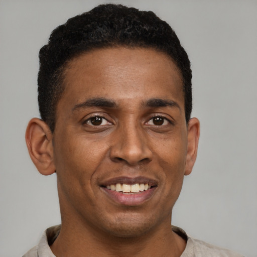 Joyful black young-adult male with short  brown hair and brown eyes