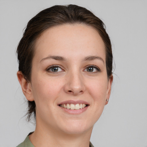 Joyful white young-adult female with medium  brown hair and grey eyes