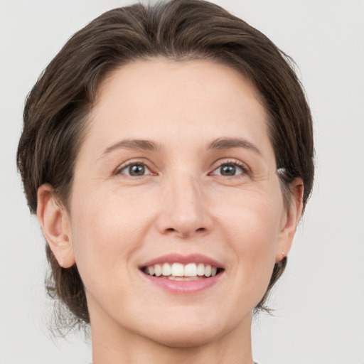 Joyful white adult female with medium  brown hair and grey eyes