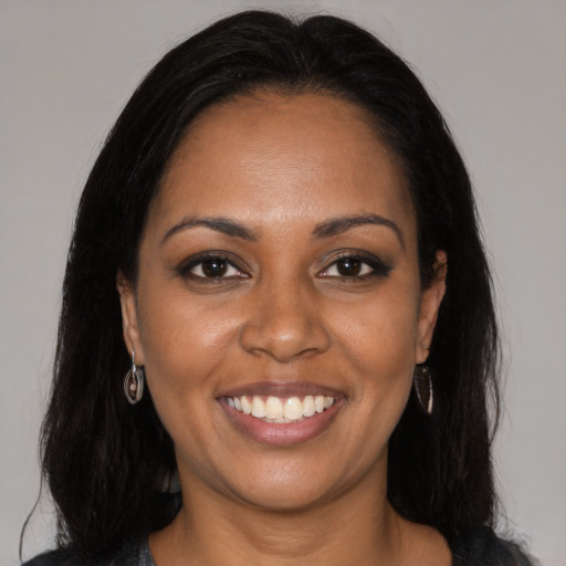 Joyful black young-adult female with long  brown hair and brown eyes