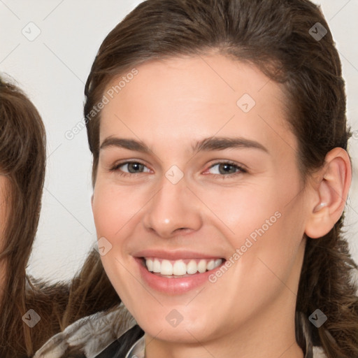 Joyful white young-adult female with long  brown hair and brown eyes