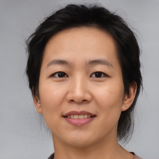 Joyful asian adult female with medium  brown hair and brown eyes