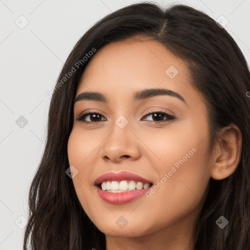 Joyful latino young-adult female with long  brown hair and brown eyes