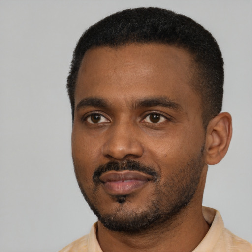 Joyful black young-adult male with short  black hair and brown eyes