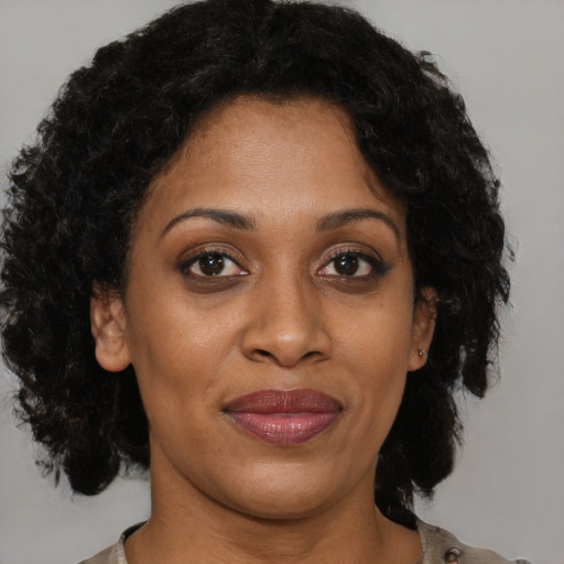 Joyful black adult female with short  brown hair and brown eyes
