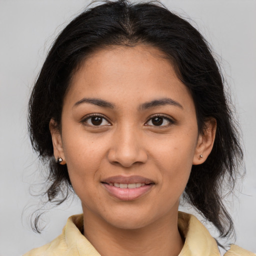 Joyful latino young-adult female with medium  brown hair and brown eyes