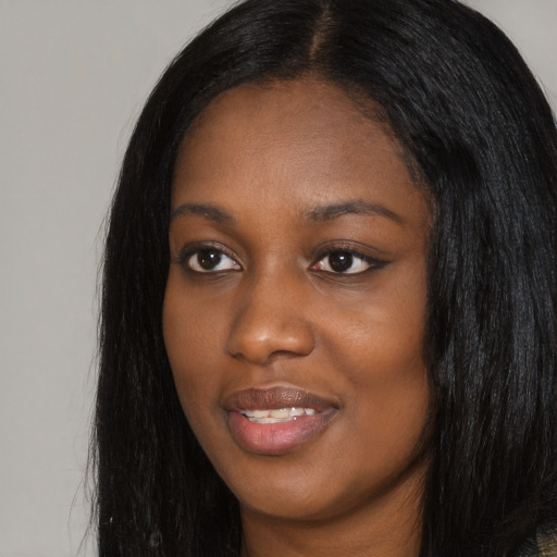 Joyful black young-adult female with long  black hair and brown eyes