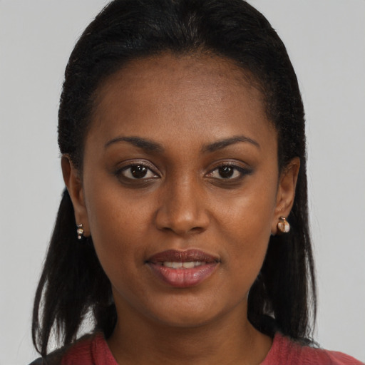Joyful black young-adult female with long  brown hair and brown eyes