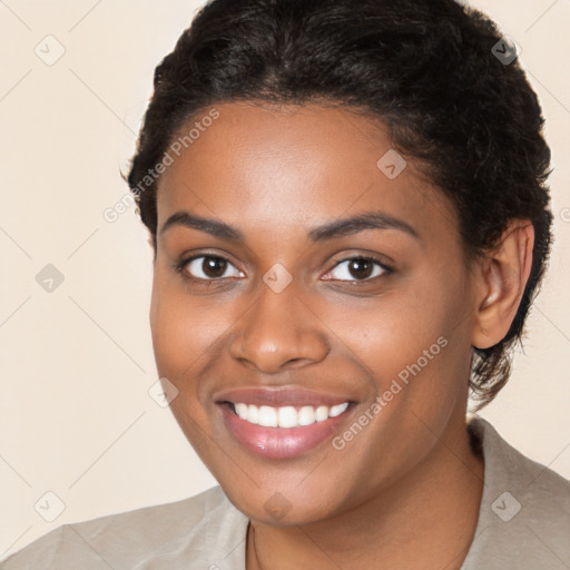 Joyful black young-adult female with long  brown hair and brown eyes