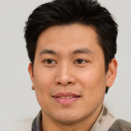 Joyful asian adult male with short  brown hair and brown eyes