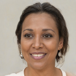 Joyful black adult female with medium  brown hair and brown eyes