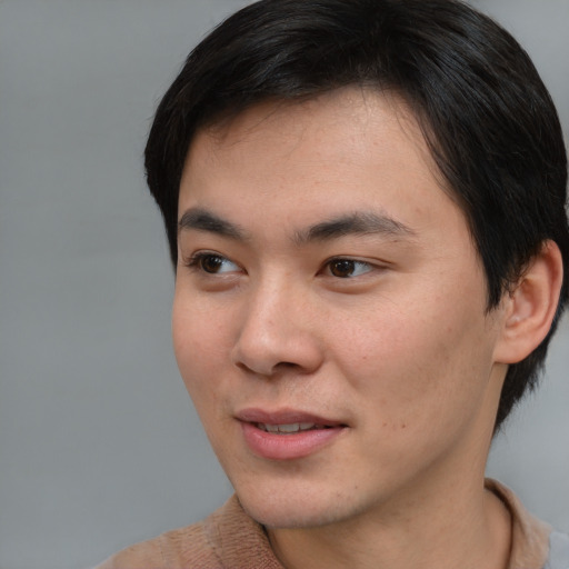 Joyful asian young-adult male with short  brown hair and brown eyes