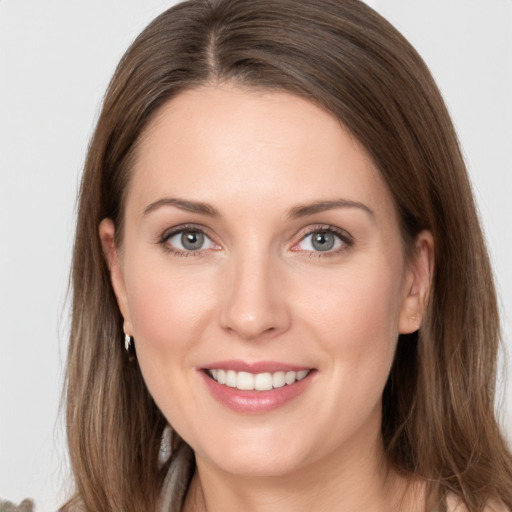 Joyful white young-adult female with long  brown hair and grey eyes