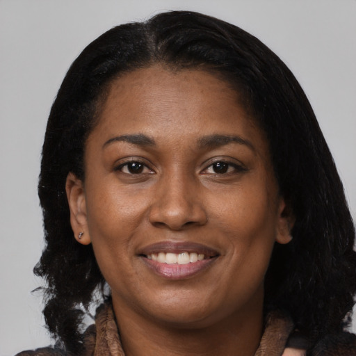 Joyful black young-adult female with medium  brown hair and brown eyes