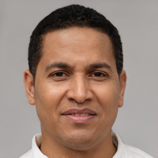 Joyful latino adult male with short  brown hair and brown eyes