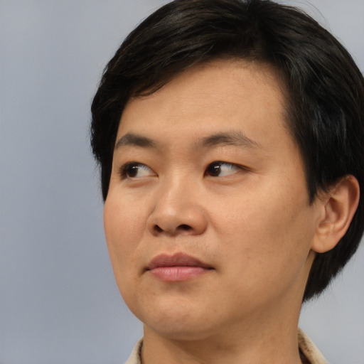 Joyful asian young-adult male with short  brown hair and brown eyes