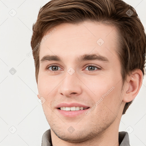 Joyful white young-adult male with short  brown hair and grey eyes