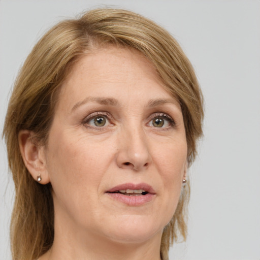 Joyful white adult female with medium  brown hair and green eyes