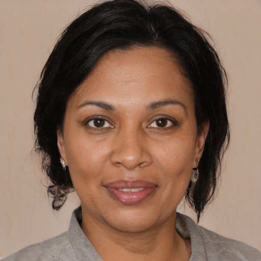 Joyful black adult female with medium  brown hair and brown eyes