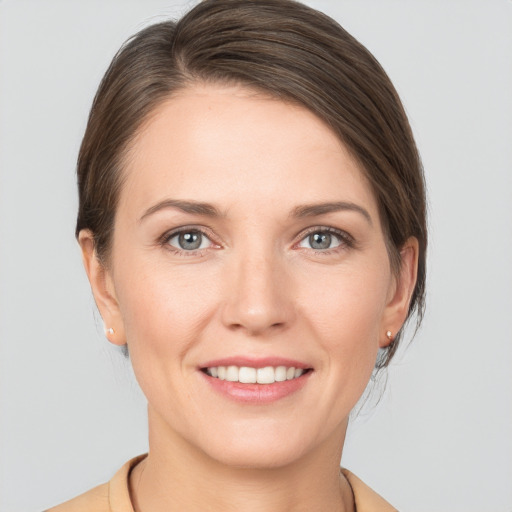 Joyful white young-adult female with medium  brown hair and grey eyes