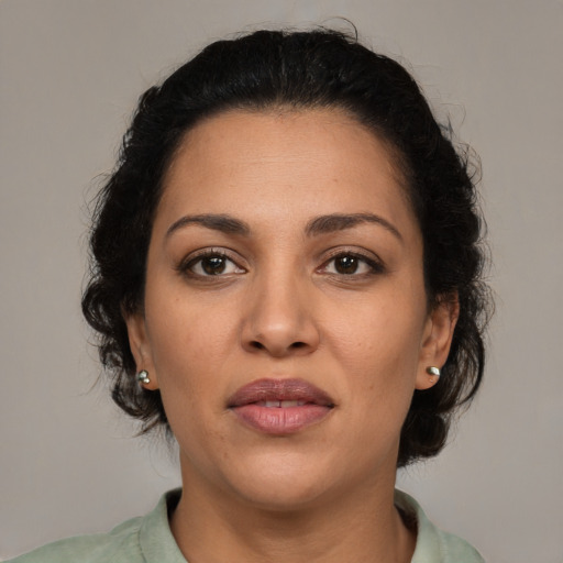 Joyful latino adult female with medium  brown hair and brown eyes