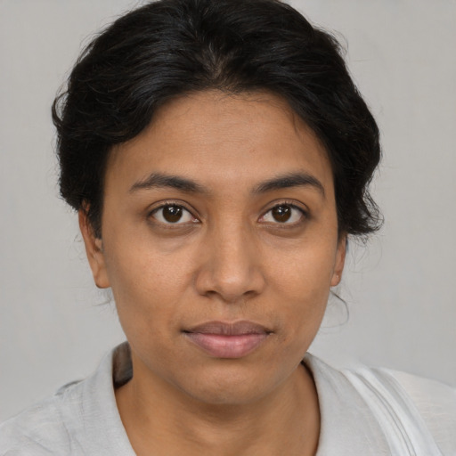 Joyful latino young-adult female with medium  brown hair and brown eyes
