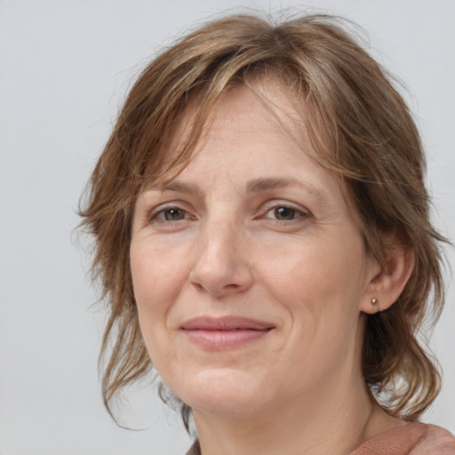 Joyful white adult female with medium  brown hair and grey eyes