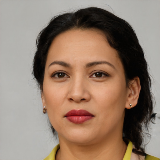 Joyful latino adult female with medium  brown hair and brown eyes